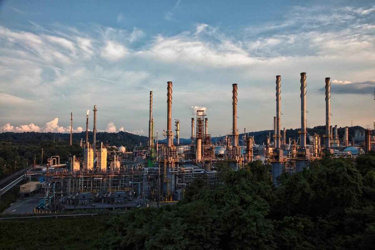 Industrial chimneys and haze over a city skyline.