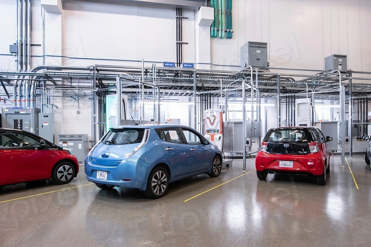 Electric cars parked at charging bays in a garage.